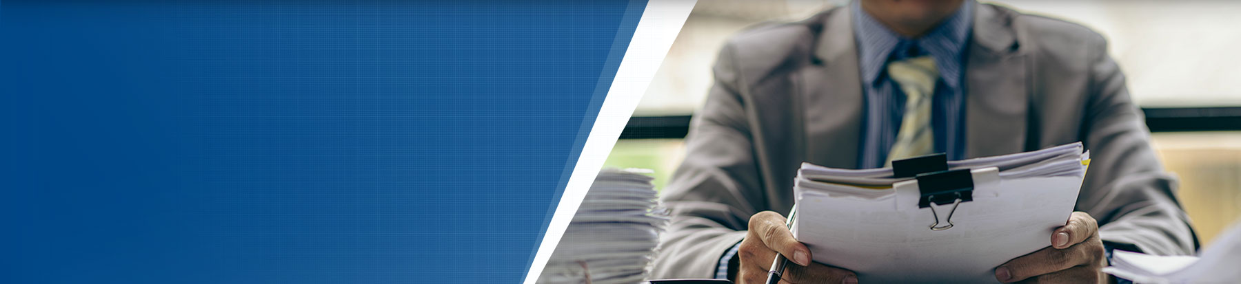 Man looking a large stack of paper work